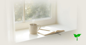 柔らかい朝の光に照らされた窓辺、湯気の立つマグカップ、ノートとペン。