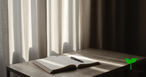 静かな朝の室内。 カーテン越しの柔らかい自然光が差し込み、 机の上には何も書かれていないノートとペン。