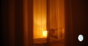 夜の室内、柔らかな灯り、静かな表情